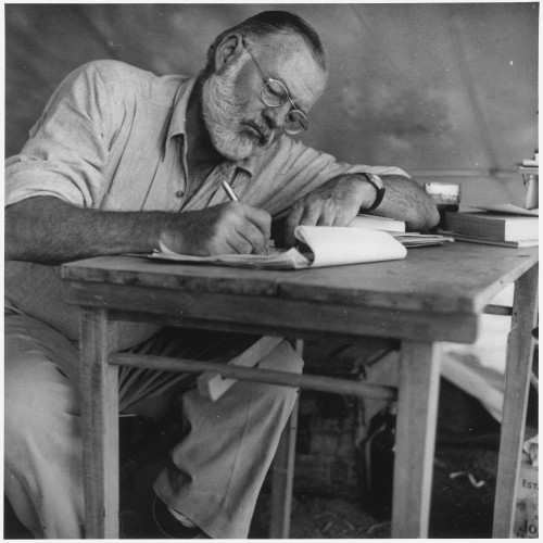 Photo: http://upload.wikimedia.org/wikipedia/commons/7/73/Ernest_Hemingway_Writing_at_Campsite_in_Kenya_-_NARA_-_192655.jpg