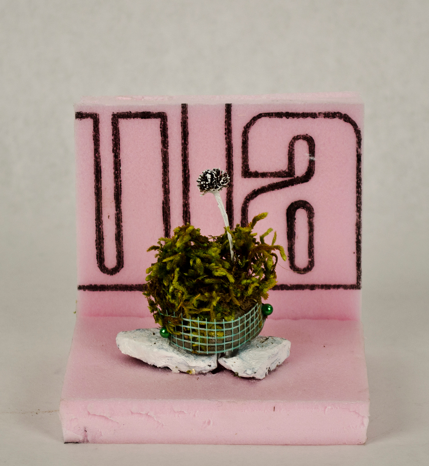 Jessica Lund, ula, 2014. Foam, gravel, drywall tape, moss, flower, gravel, pins, paint, 4 x 4 x 4 in.