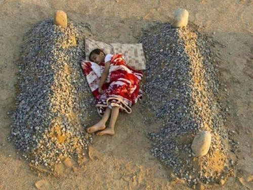 A young Syrian boy asleep—or possibly dead himself, drenched in blood—lies on the ground between two graves. This photo was taken by Saudi photographer Abdel Aziz Al-Atibi, as part of a conceptual art project. “I’m a photographer and I try to talk about the suffering that is happening in society.”