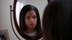 Black woman looking at herself in the mirror