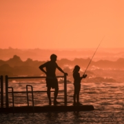 Father and child fishing in the sunrise