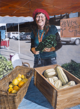 a woman hold kale in her hand at a farmers market
