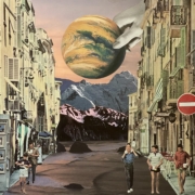 Planet held by a hand over the mountains viewed from a front street where people are walking
