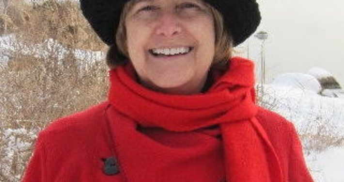 Jennifer M Phillips Headshot red coat black hat