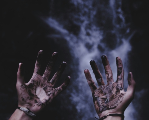 Dirtied hands with smoke and black background