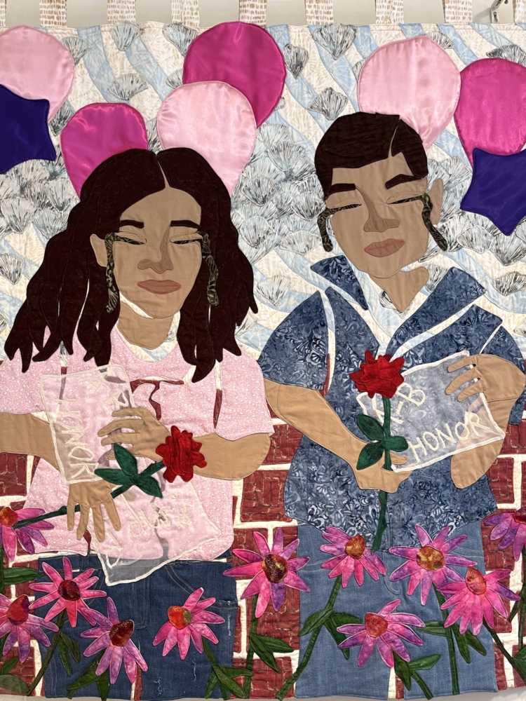 Two people in pink and blue with balloons and a brick wall, pink daisies