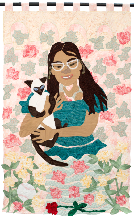 Person in teal holding cat with peach flowers