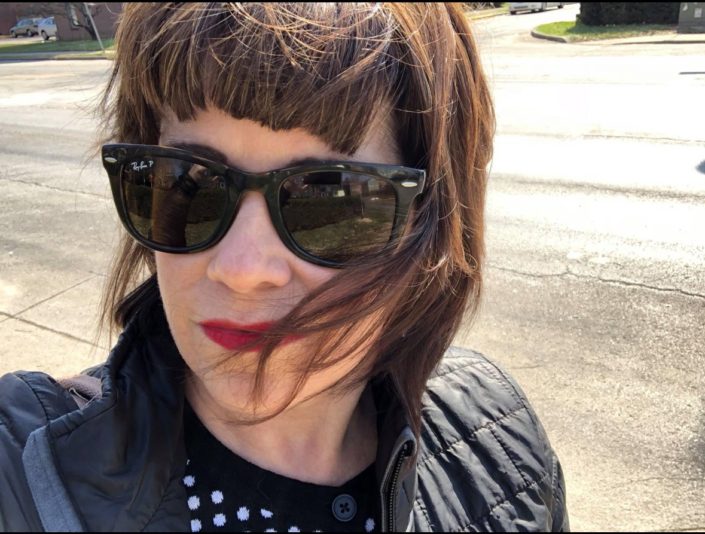 Julia Johnson wearing sunglasses and taking a selfie.